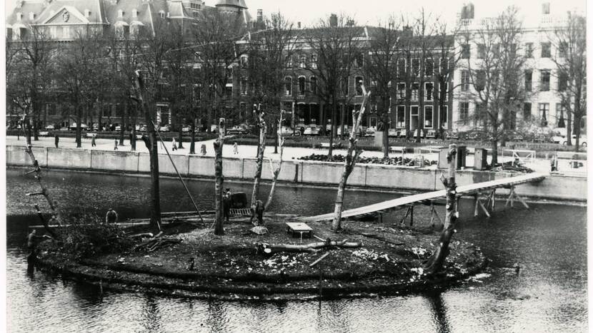 Werkzaamheden op het eiland in de Hofvijver; de bomen zijn gesnoeid en een lange loopplank verbindt het eiland met de Lange Vijverberg