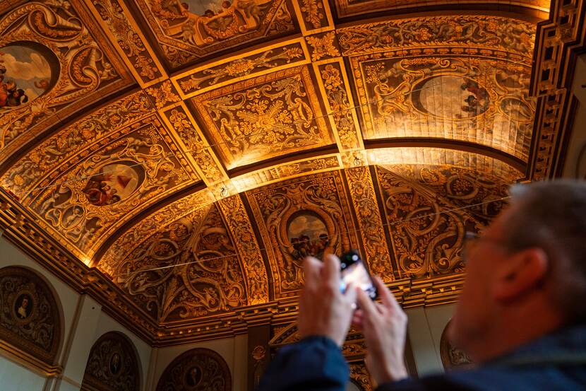 Bezoeker fotografeert beschilderd plafond Eerste Kamer op Dag van de Bouw Binnenhof 2024