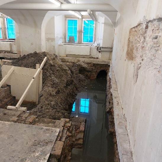 Water onder een weggehaalde de vloer in de kelder van het Eerste Kamergebouw