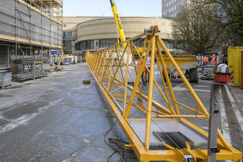 De giek van de torenkraan ligt op de Hofplaats, op de achtergrond van de 70 meter lange giek is de plenaire zaal van de Tweede Kamer te zien