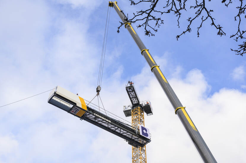 Het eerste deel van de giek van de torenkraan op de Hofplaats wordt door de mobiele kraan omhoog gehesen