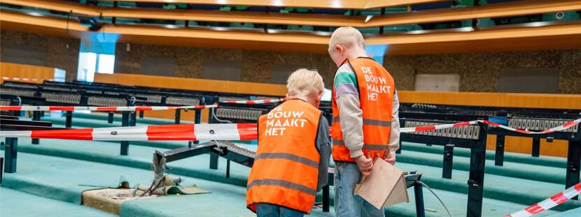 Twee jonge bezoekers in de plenaire zaal Tweede Kamer tijdens Dag van de Bouw 2024