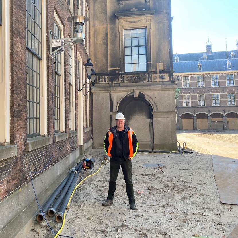 Fred Pannekoek staat op het Binnenhof bij een Robotic Total Station